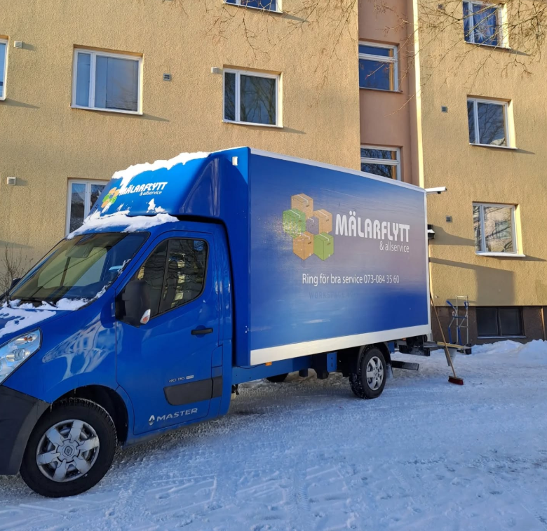 Mälarflytt & Allservice skåpbil parkerad i snön utanför en byggnad, relaterad till flyttfirma i Västerås.